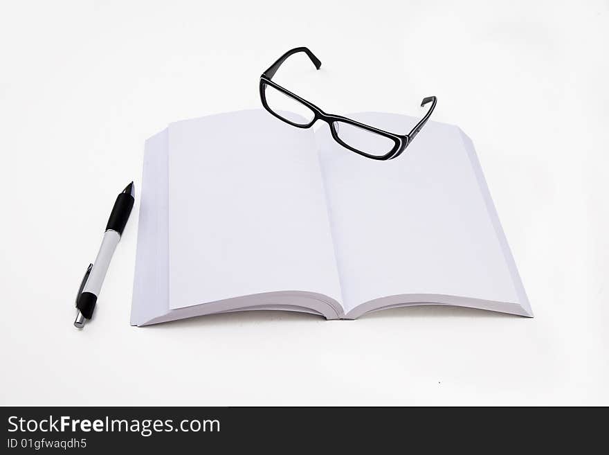 A blank pages book with a pen and eyeglasses. A blank pages book with a pen and eyeglasses