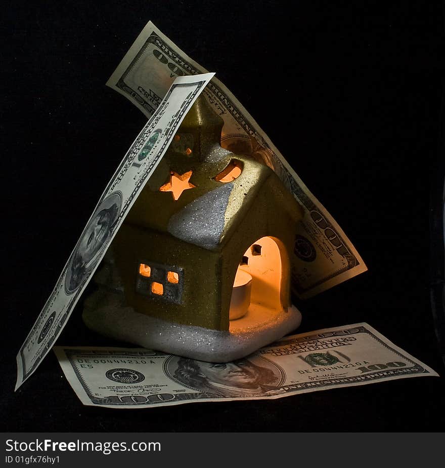 The small house covered by dollars and shined from within, in a night-time, at night