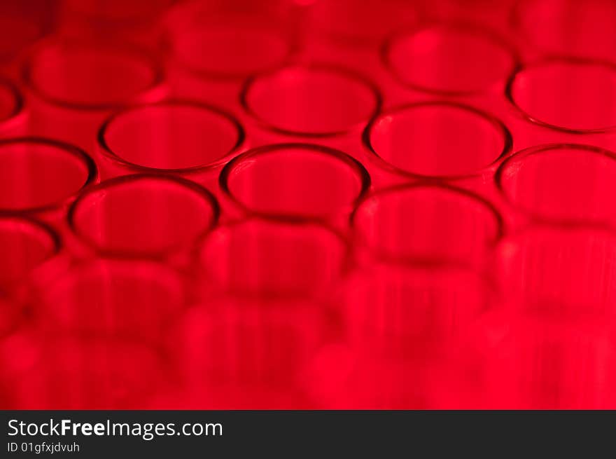 Close-up of empty glass test tubes in red