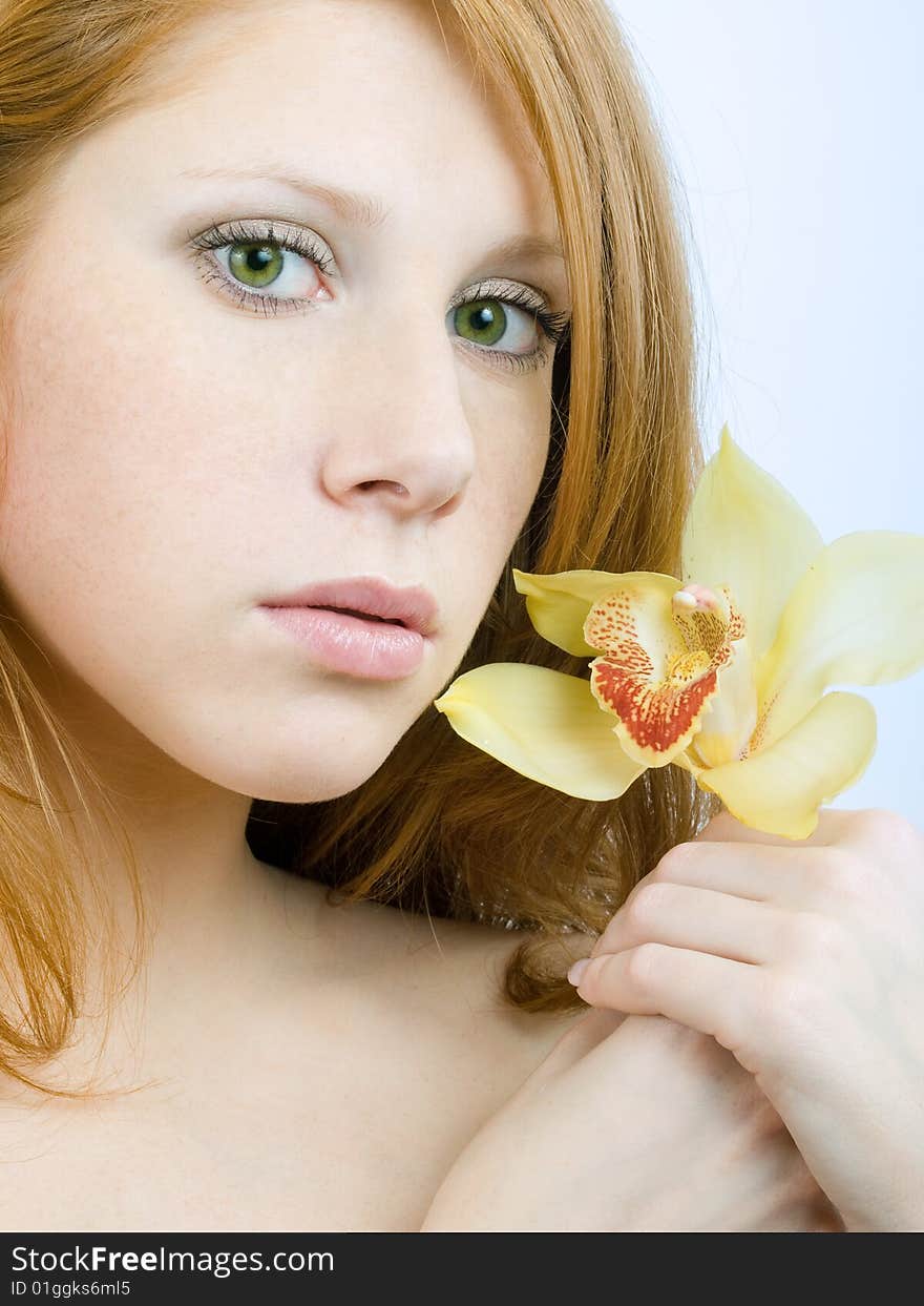 Redheaded girl with an orchid at hands. Redheaded girl with an orchid at hands