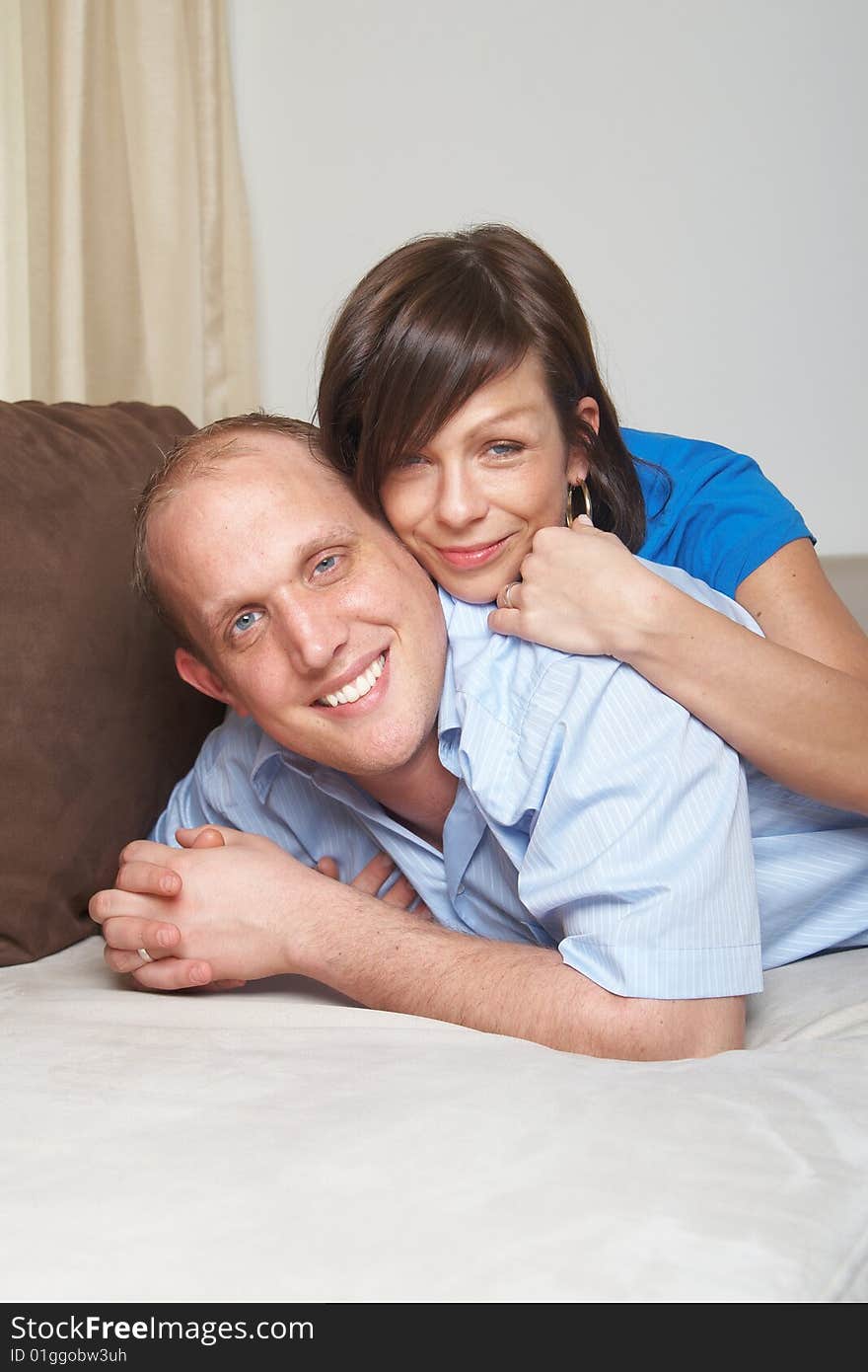 Beautiful young couple on a couch in their new appartment. Beautiful young couple on a couch in their new appartment.