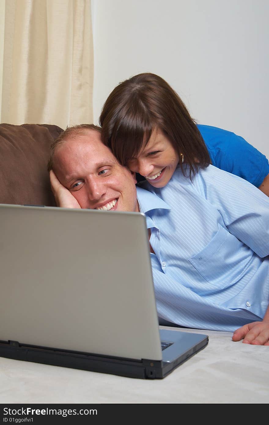 Young couple on the couch at home looking at the laptop!. Young couple on the couch at home looking at the laptop!