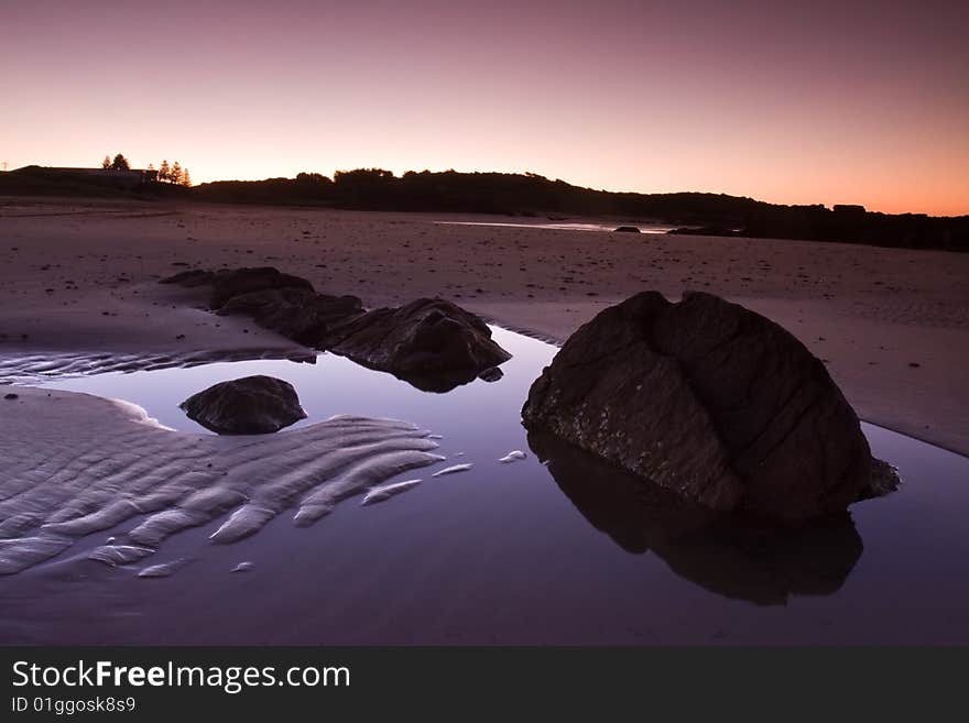 Beautiful beach and reflected stone formation taken in Anna Bay, NSW, Australia during twilight conditions.