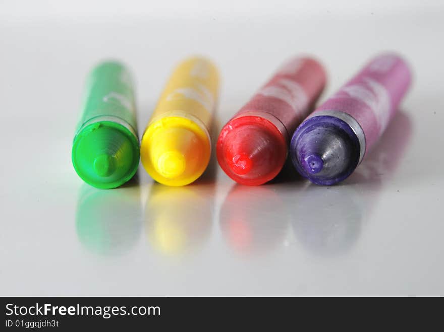 Crayons in different colors lying on a shiny desk. Crayons in different colors lying on a shiny desk