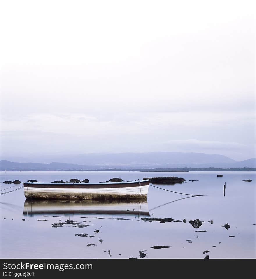 Fisherman boat in the middle of a blu quiet lagoon