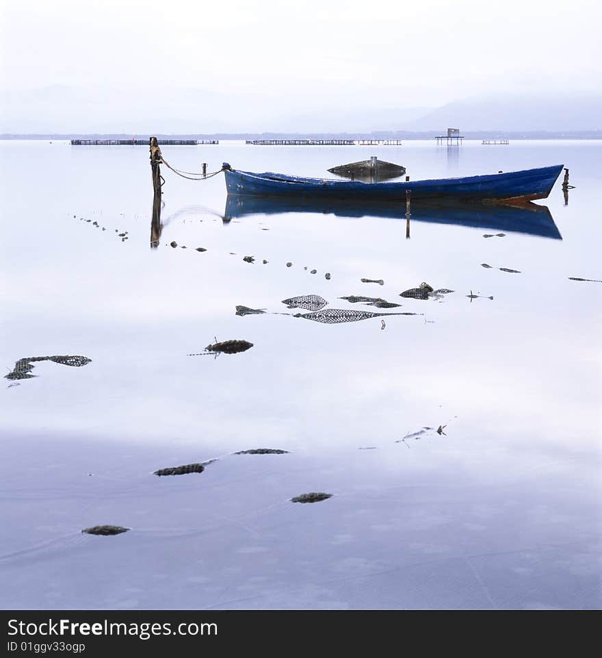 Fisherman boat in the middle of a blu quiet lagoon