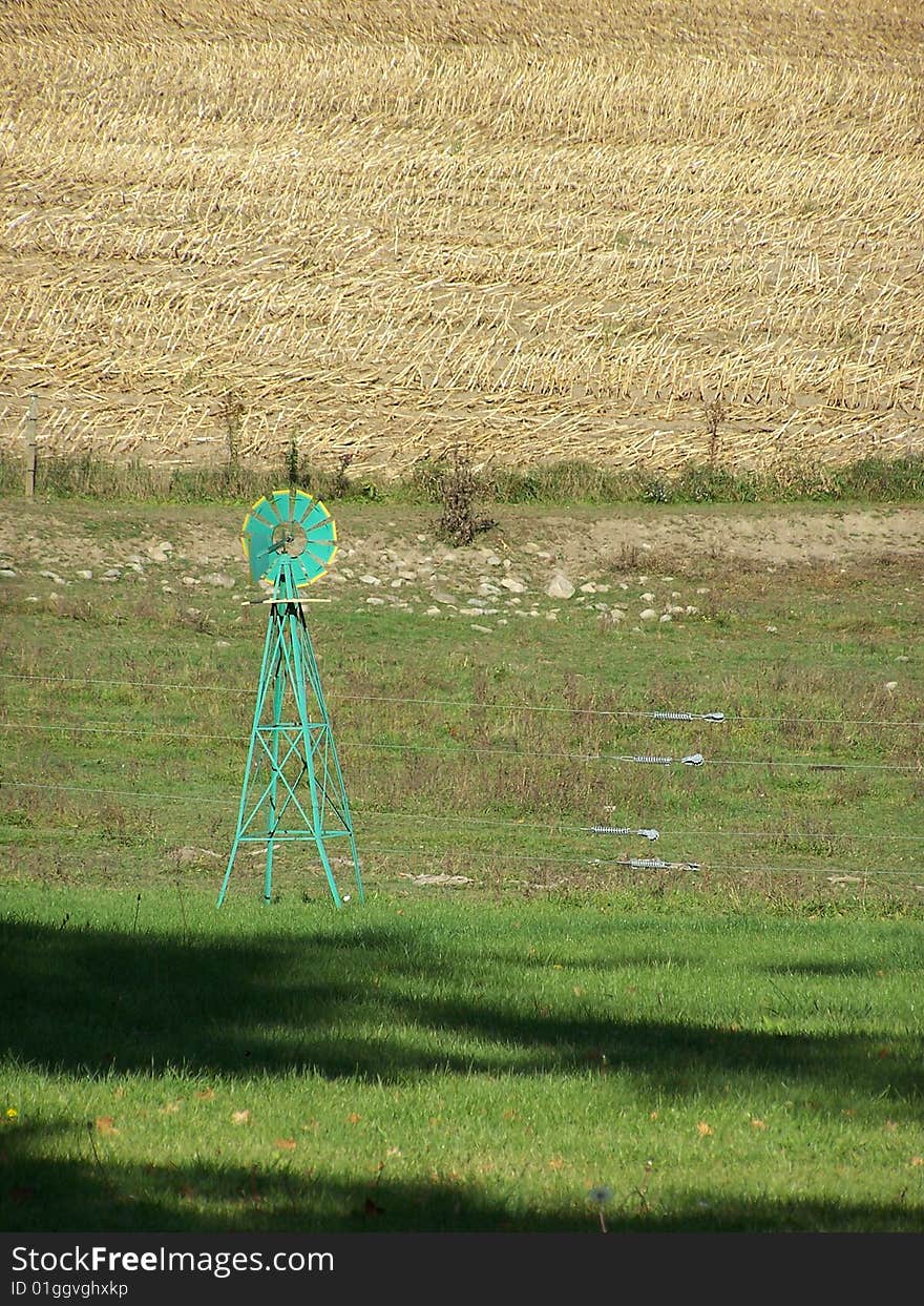 Green windmill against harvested field. Green windmill against harvested field