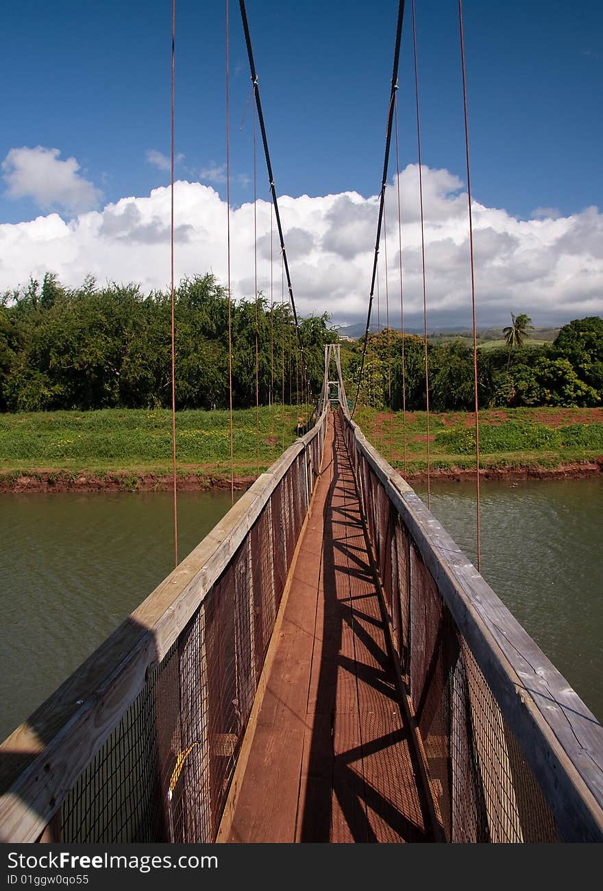 View down the walkway of the swinging suspension bridge at Hanapepe. View down the walkway of the swinging suspension bridge at Hanapepe