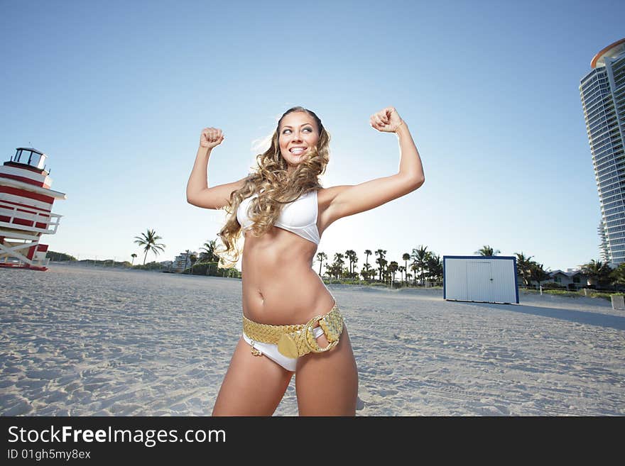 Woman on the beach flexing