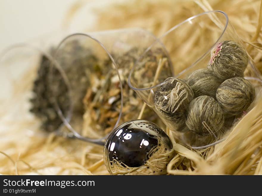 Silver tea-strainer and tree kinds of tea on strow