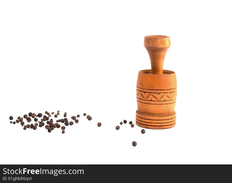 Old pepper mill with black pepper isolated in white background