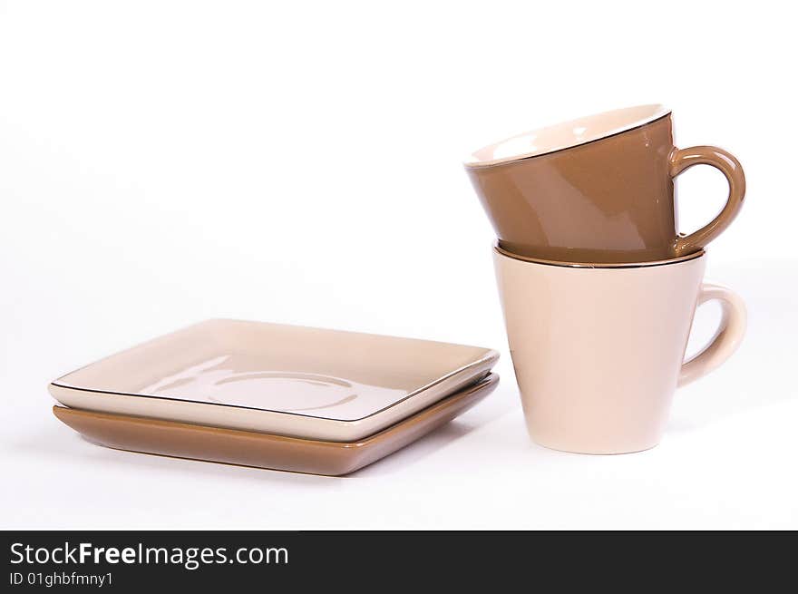 Two brown and beige cups of tea with saucers