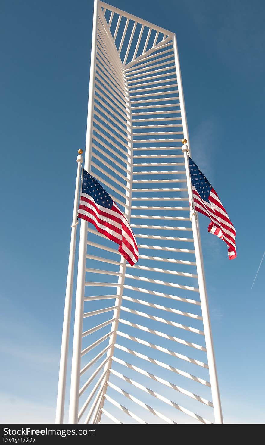 Two American flags frame a tall monument.