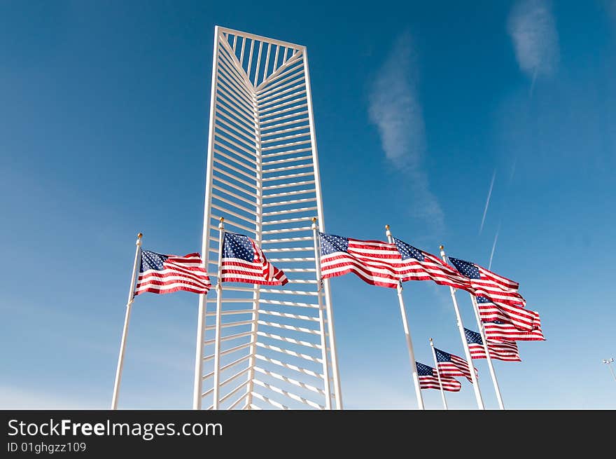 Two American flags frame a tall monument.