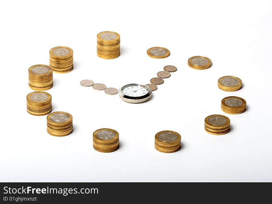 Coins in the shape of a clock with a watch in the middle on white background. Coins in the shape of a clock with a watch in the middle on white background