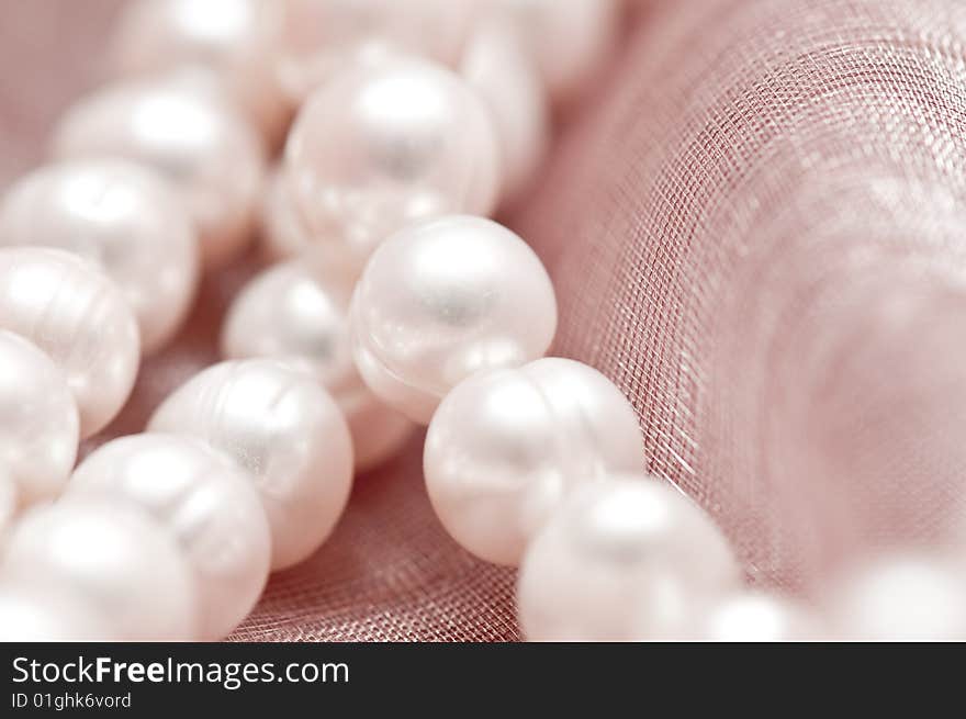 Beads of pearl on the pink background