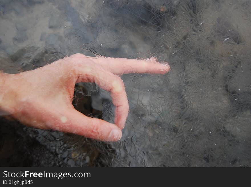 Image illustrates the most popular finger position (It's OK) in the art manner. This is a hand under the ice. It is winter. It's Kazhdan Valeriy's hand (autor of the photo).