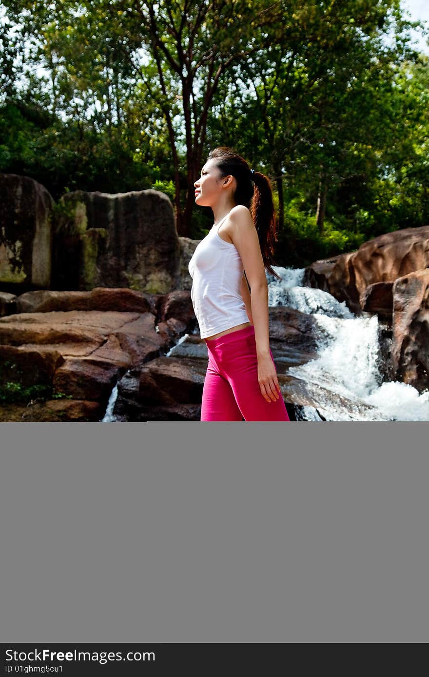 Outdoor waterfall young woman stretching her body. Outdoor waterfall young woman stretching her body