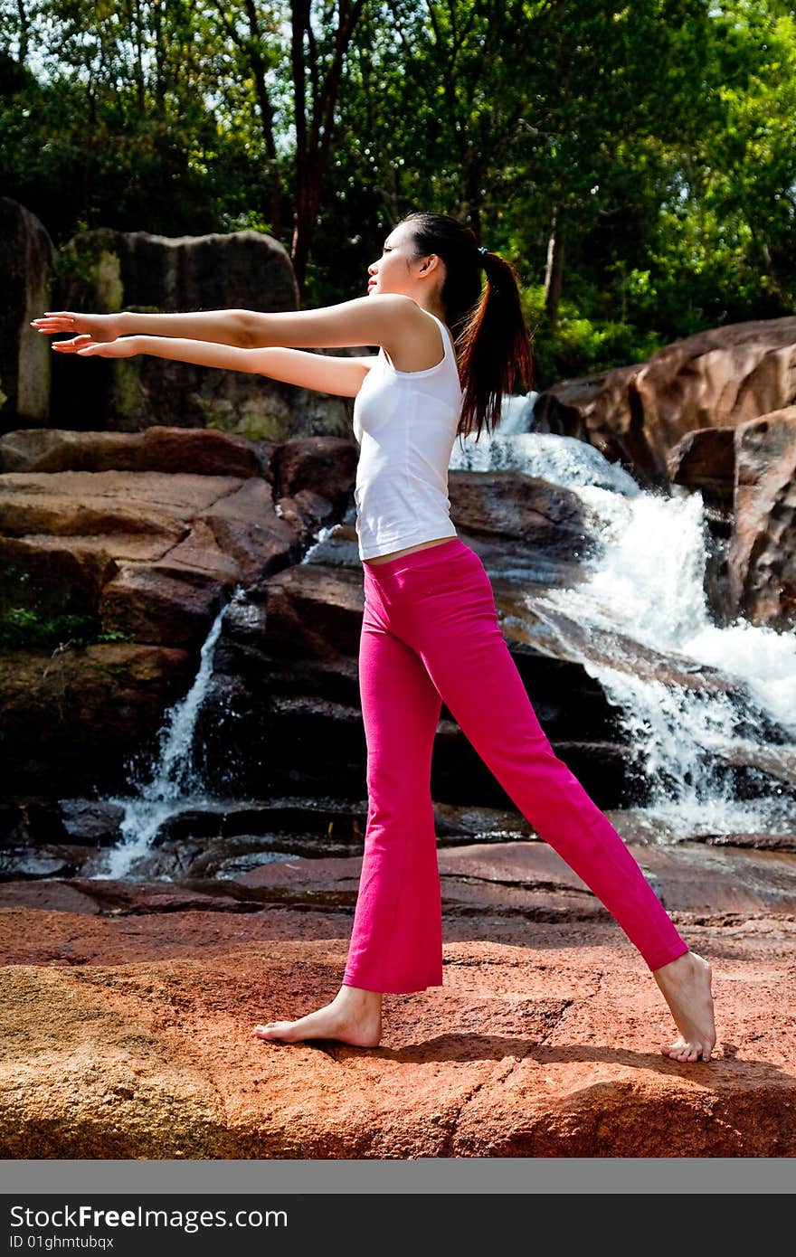 Young Woman Relaxing At The Waterfall