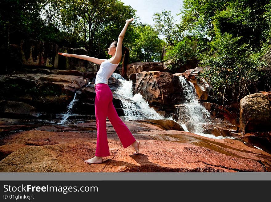 Young Woman Relaxing At The Waterfall