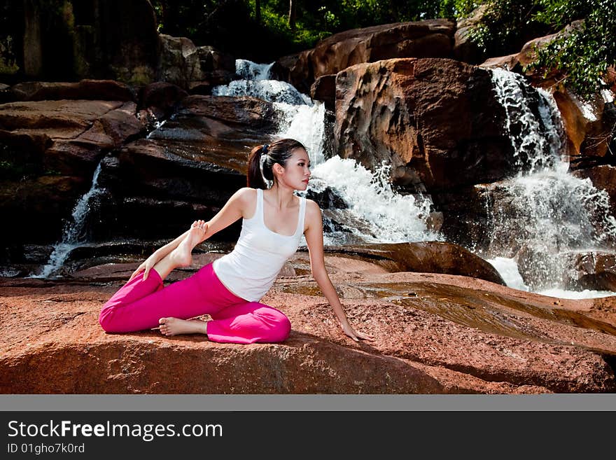 Young woman relaxing by the waterfall