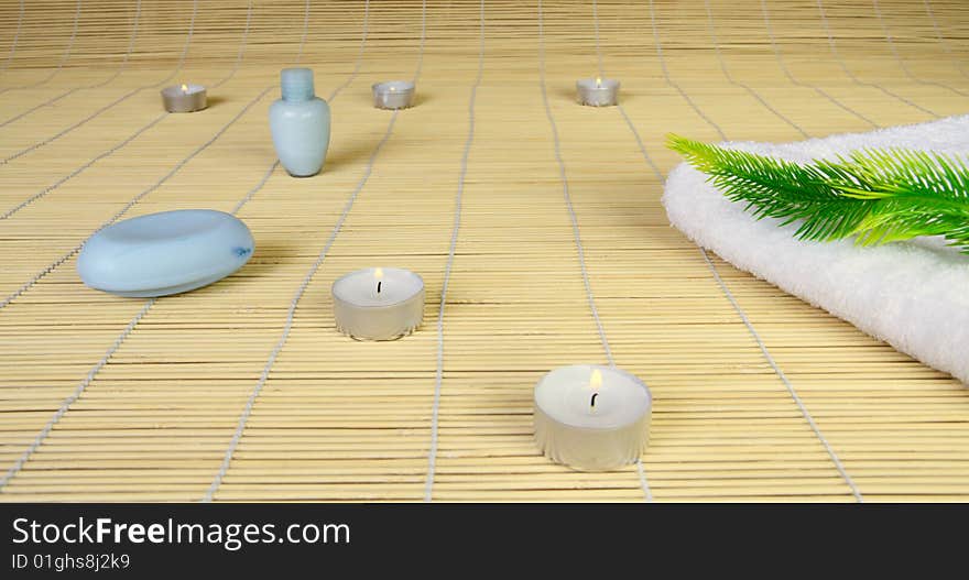 Spa objects: candles, soap, towel and plant.