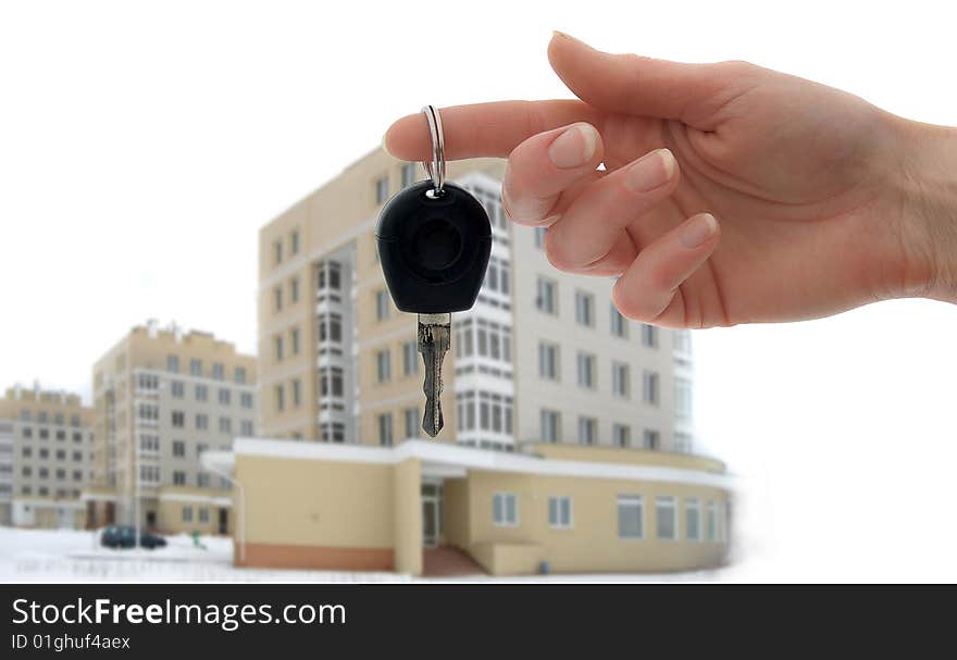 Key and hand on background of new houses