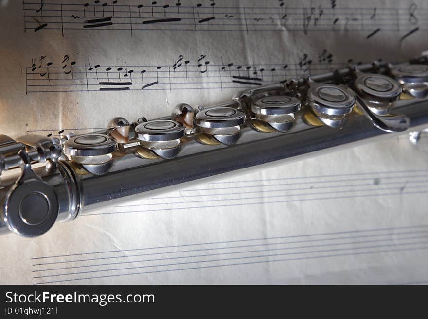 Western concert flute with a old sheet music. Western concert flute with a old sheet music