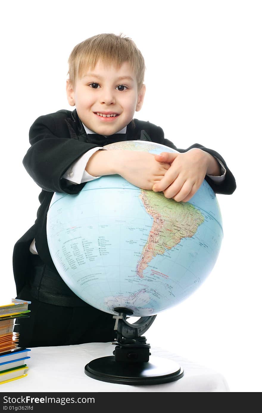 Happy little schoolboy smiling and embracing a big globe. Happy little schoolboy smiling and embracing a big globe