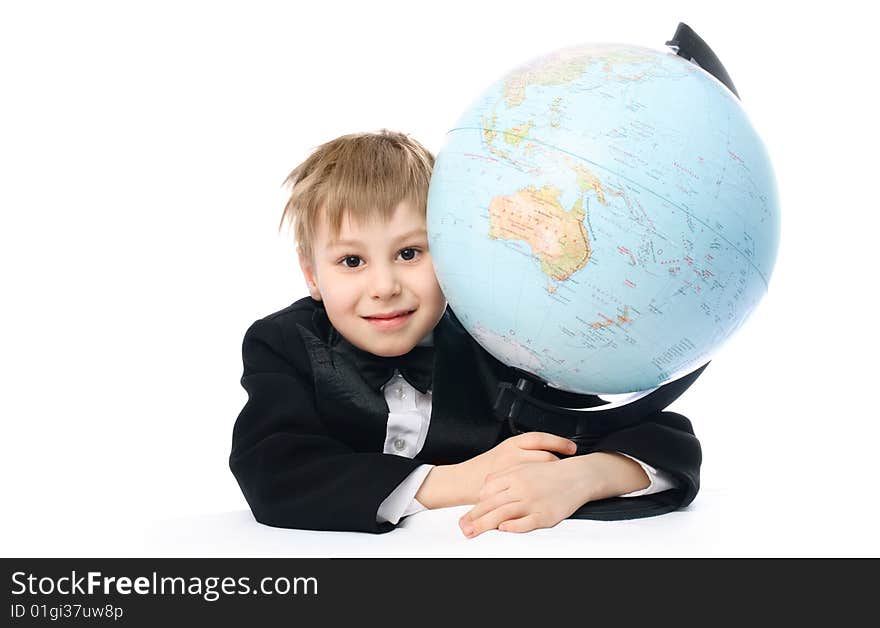 Happy schoolboy sitting by the table and embracing a big globe. Happy schoolboy sitting by the table and embracing a big globe