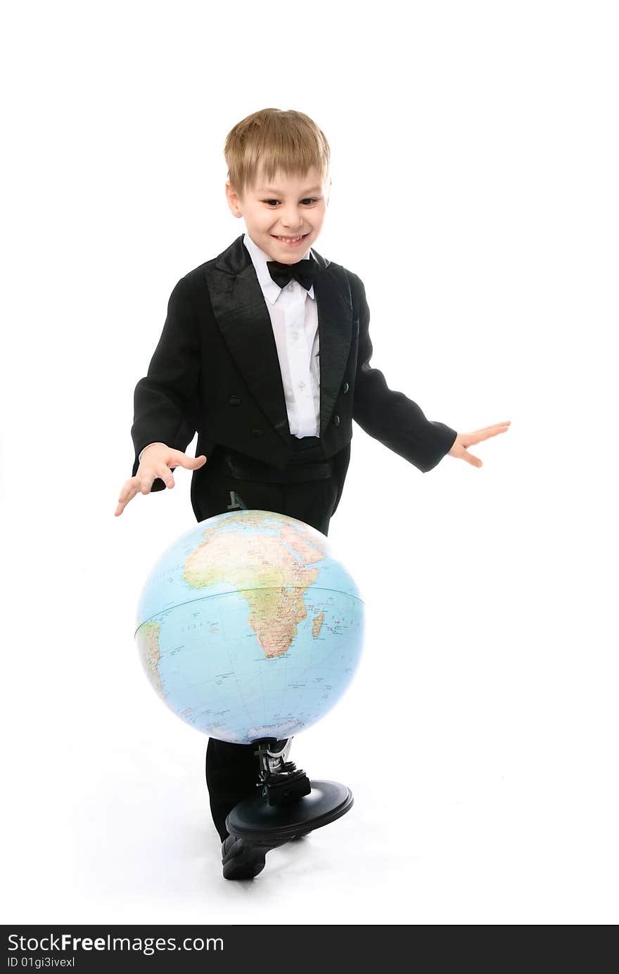 Happy playful  little schoolboy balancing a globe on his foot and pretending he is playing football. Happy playful  little schoolboy balancing a globe on his foot and pretending he is playing football