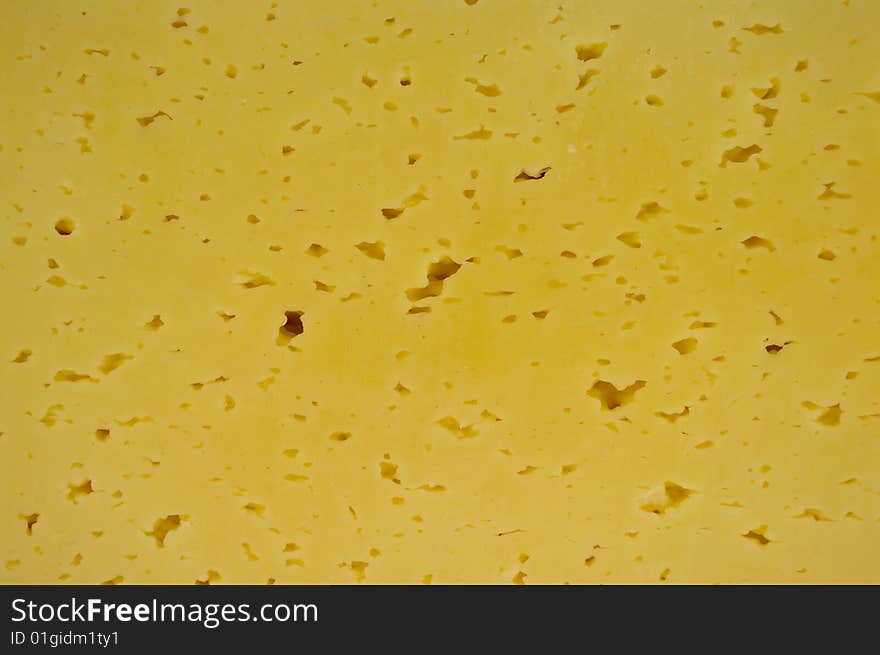 Yellow cheese with holes as a background