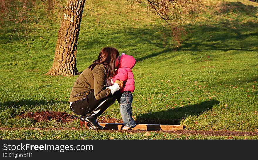 Mummy kissing daughter on a sunny day