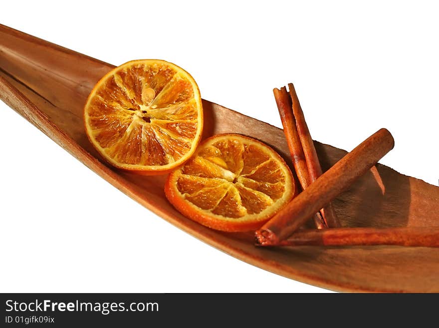 Scented cinnamon sticks and orange slices on dried cocco leaf, isolated on white. Scented cinnamon sticks and orange slices on dried cocco leaf, isolated on white