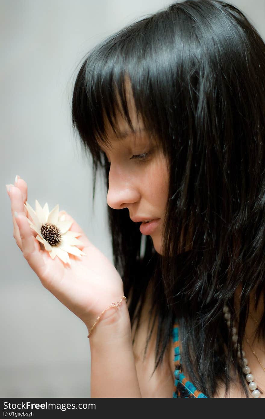 Beautiful girl with artificial flower in her hand. Beautiful girl with artificial flower in her hand