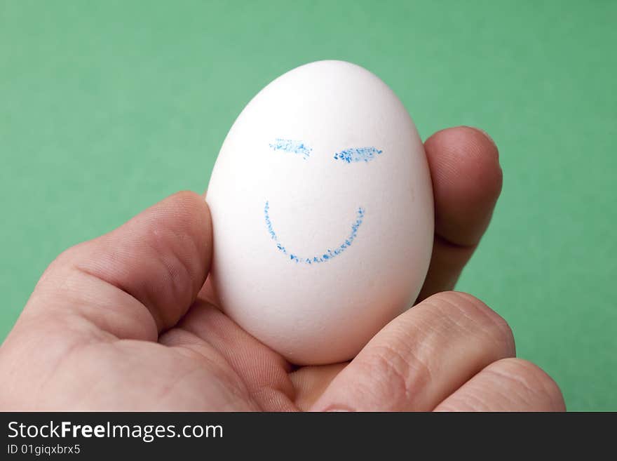 An egg decorated in blue crayon with a happy smiley face. An egg decorated in blue crayon with a happy smiley face.