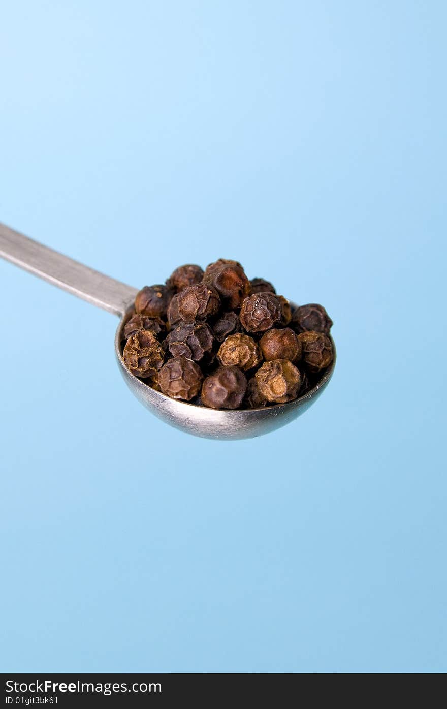 Image of table spoon with black pepper seeds. Image of table spoon with black pepper seeds