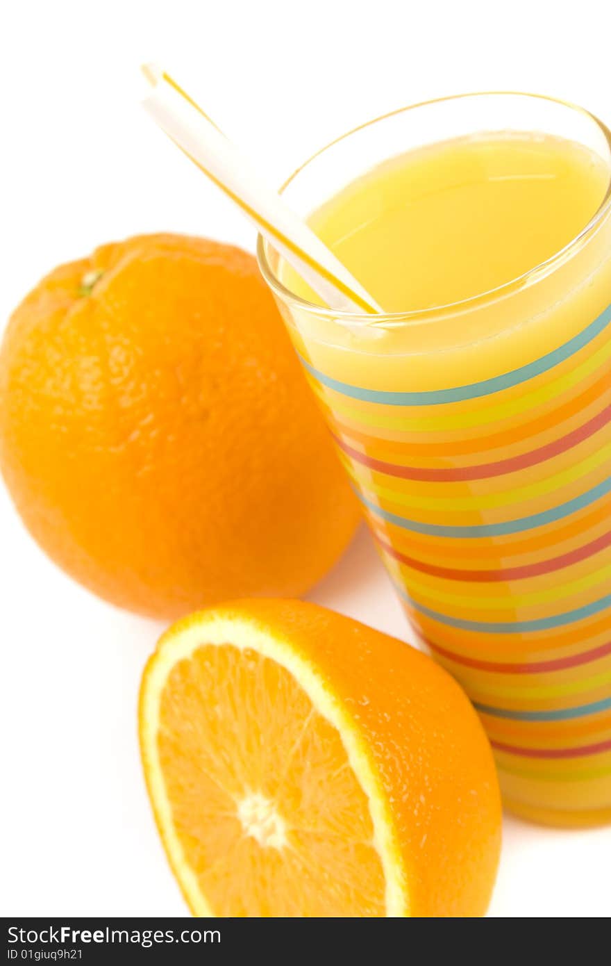 Glass of juice and oranges closeup on white