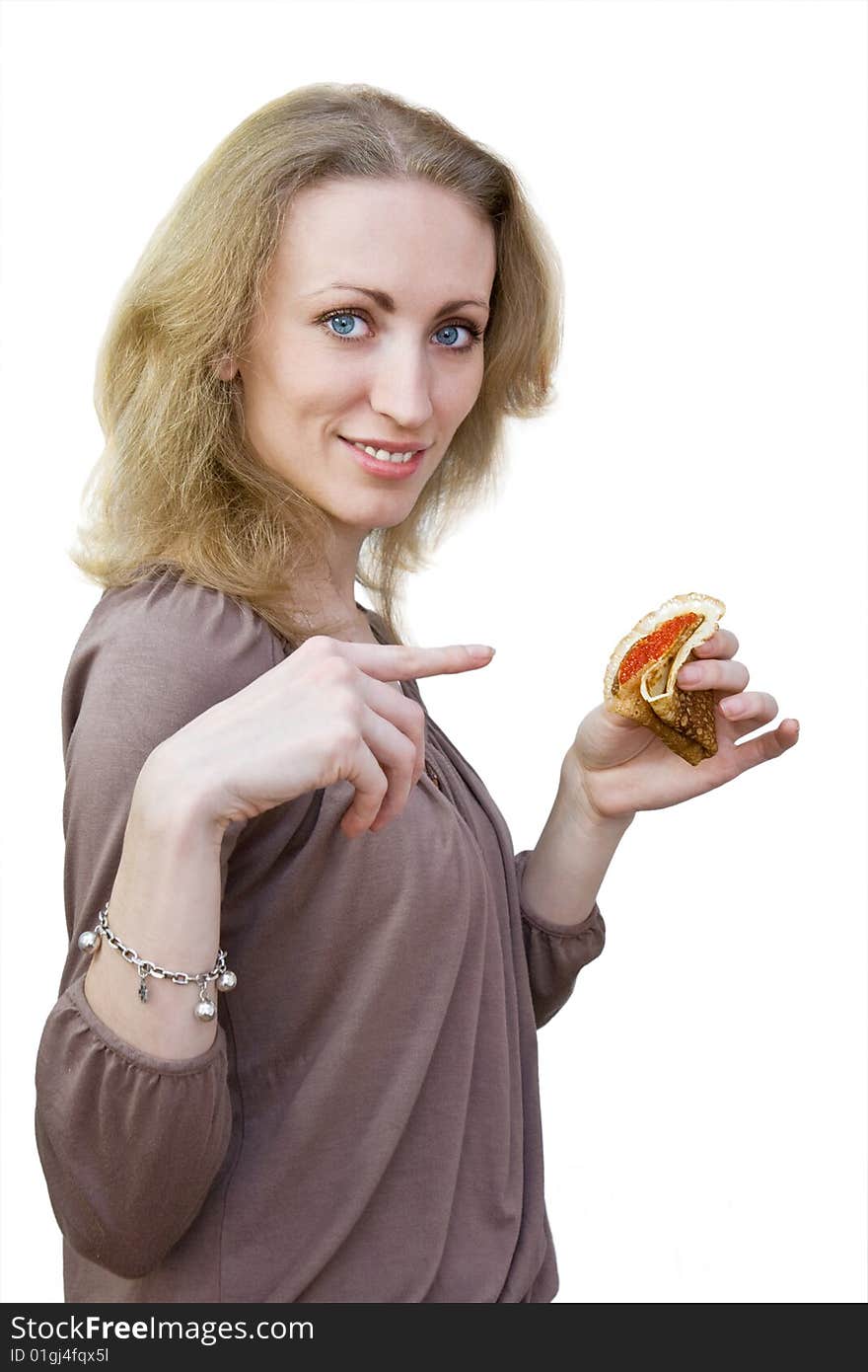 Smiling girl shows on a pancake with red caviar