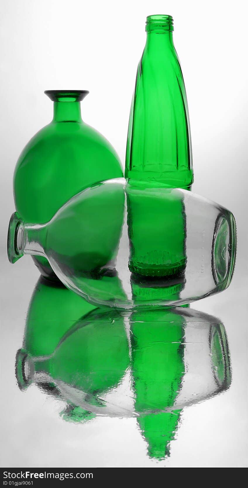 Three bottles made of white and green glass.