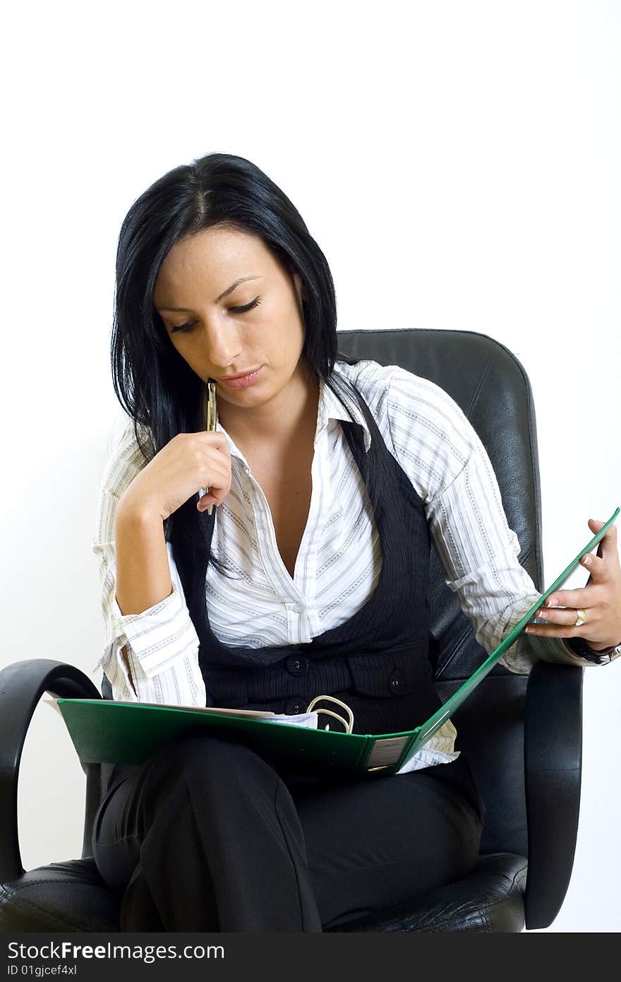 Attractive businesswoman in office chair with folder and pen