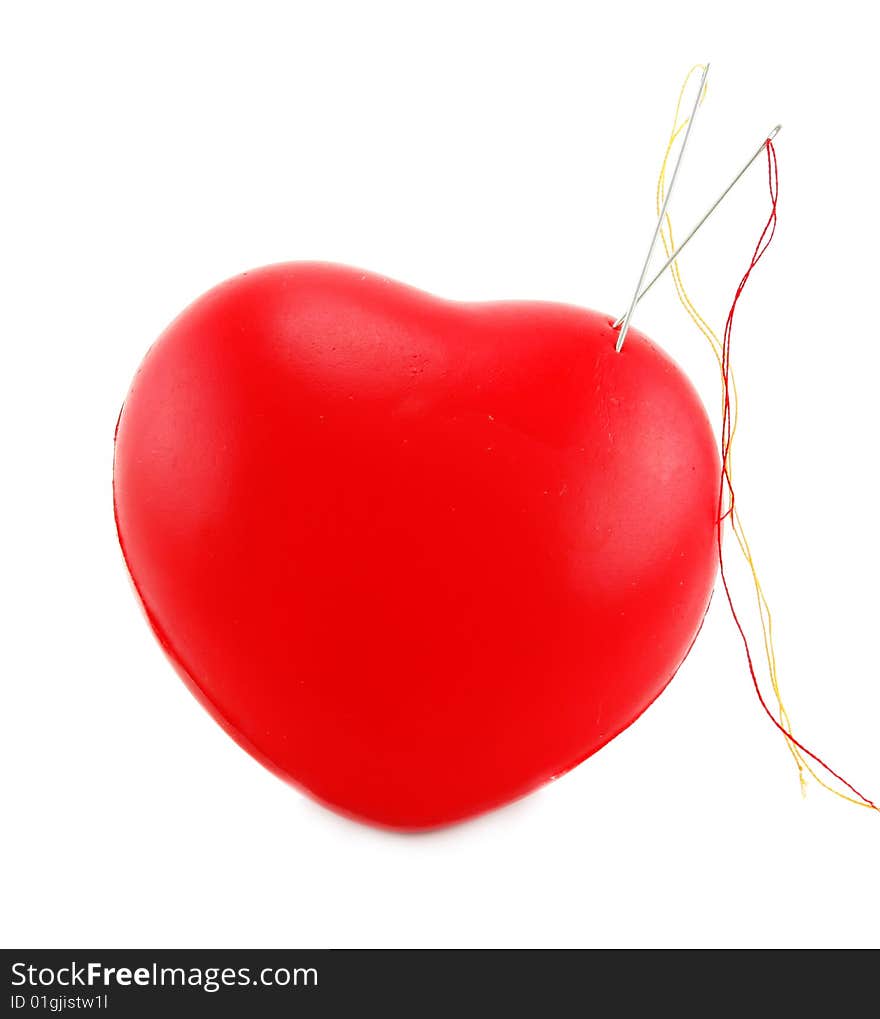 Heart shaped pincushion with two needles isolated on a white background