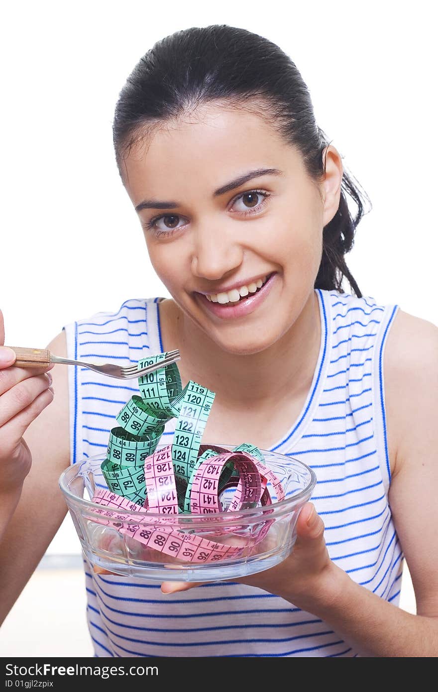 portrait of a young woman eating measuring tape with a fork. portrait of a young woman eating measuring tape with a fork