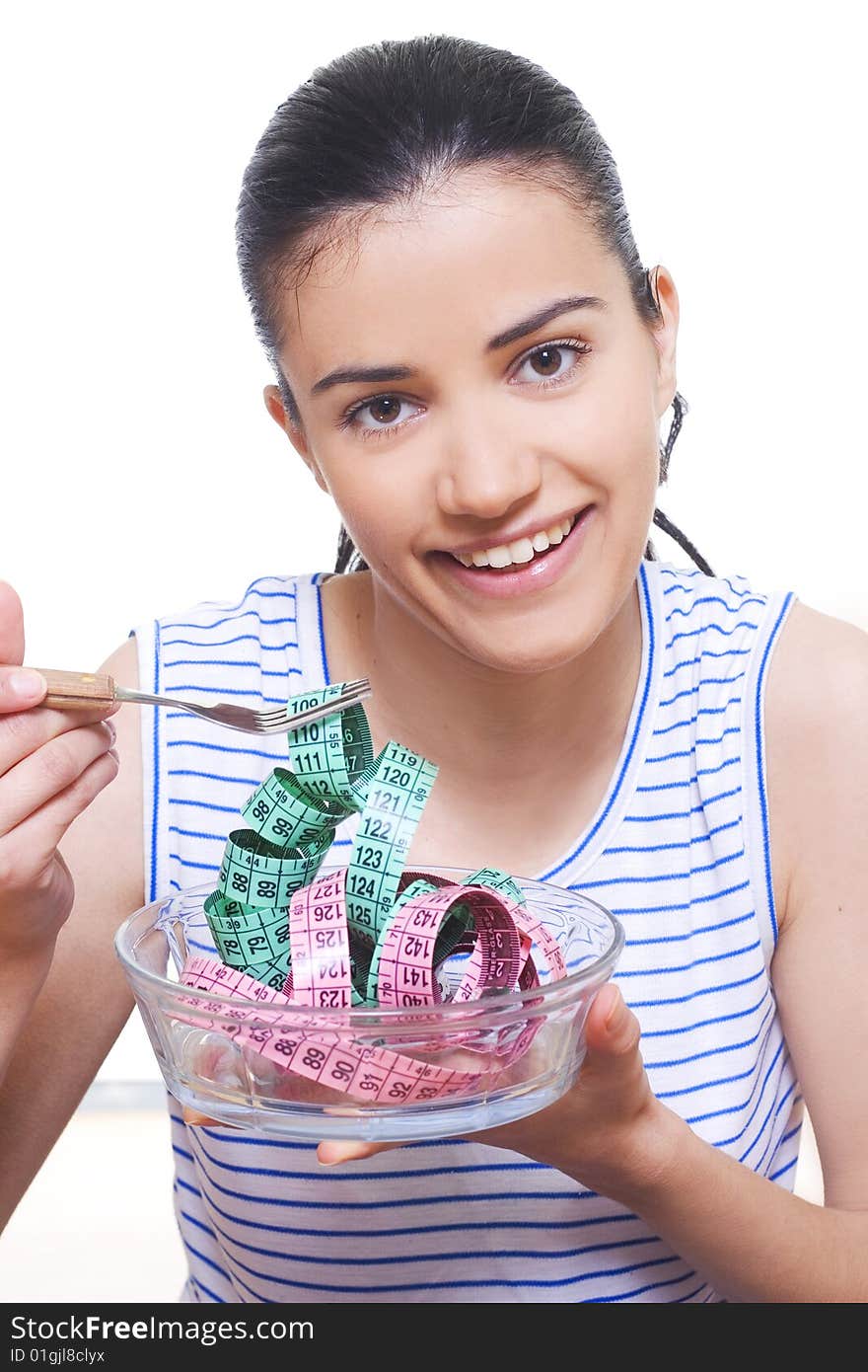 Portrait of a young woman eating measuring tape with a fork. Portrait of a young woman eating measuring tape with a fork