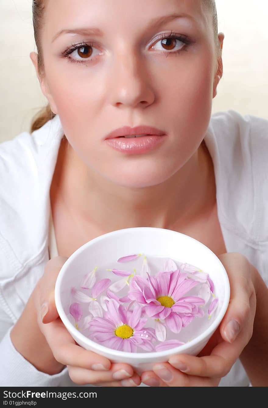 Beautiful young woman with bowl of flowers. Beautiful young woman with bowl of flowers