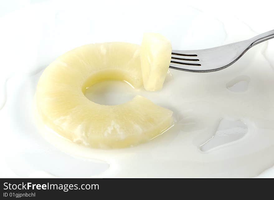 Slice of pineapple with liquid and fork