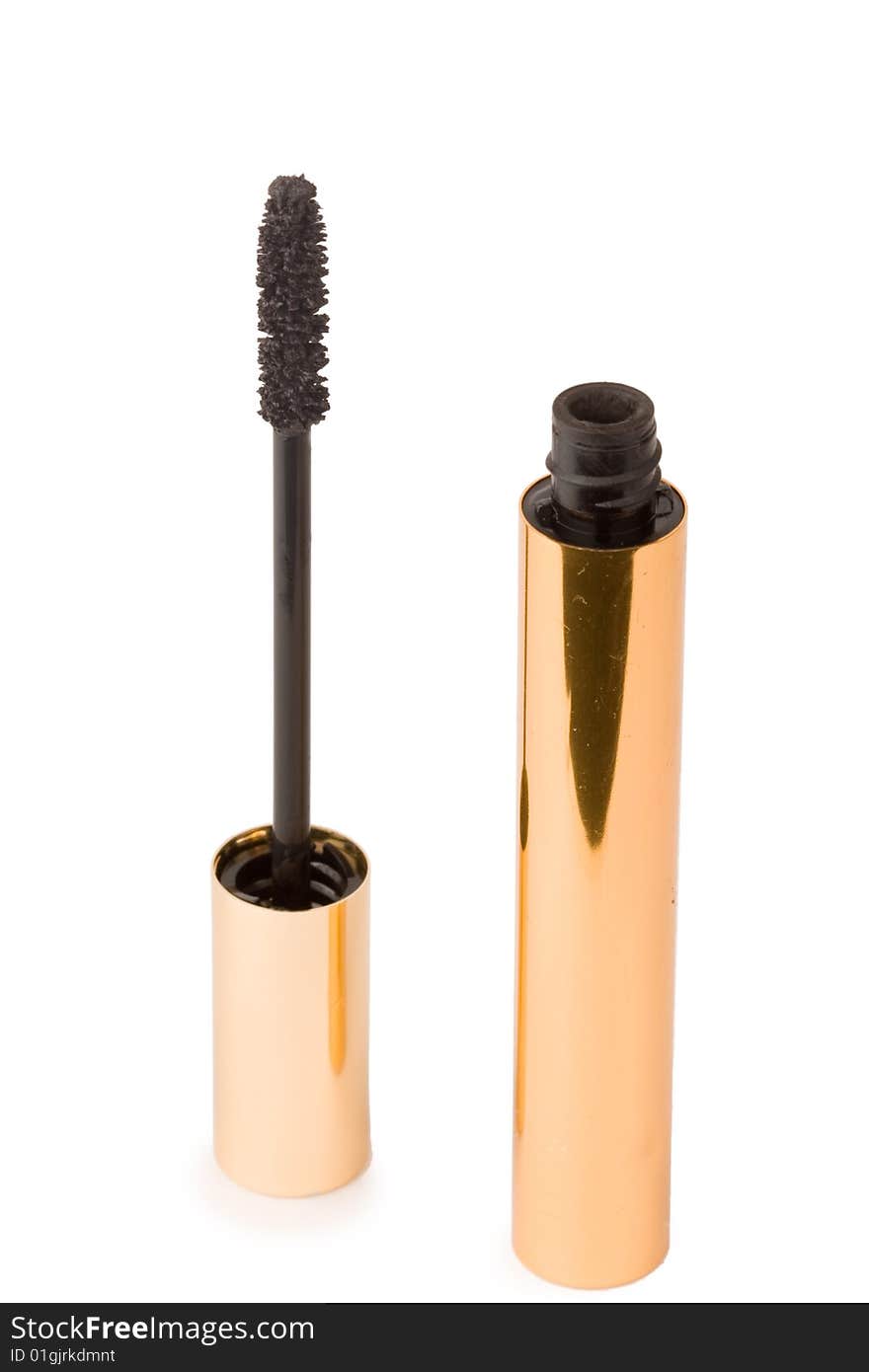 Gold mascara and brush on white background