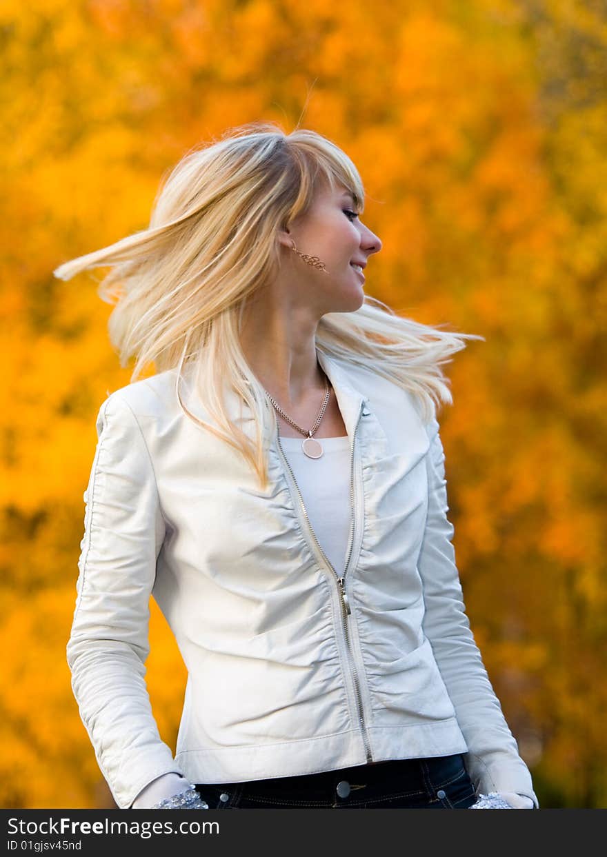 Pretty girl in white jacket on autumn park background - shallow DOF