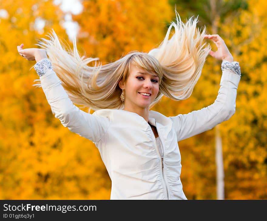 Pretty girl in white jacket on autumn park background - shallow DOF