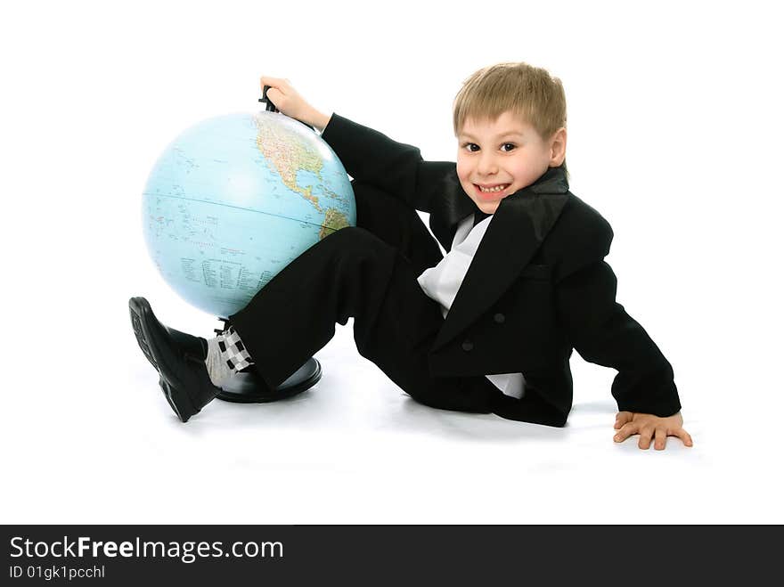 Happy schoolboy sitting on the floor with a big globe standing near him. Happy schoolboy sitting on the floor with a big globe standing near him